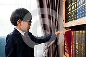 Little boys in suit looking and choose book