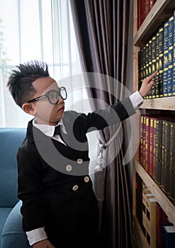 Little boys in suit looking and choose book