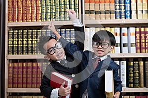 Little boys in suit looking and choose book