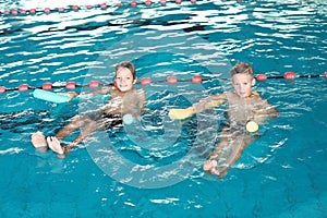 Little boys with swimming noodles