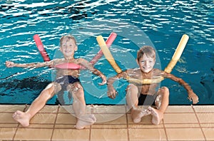 Little boys with swimming noodles