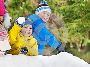 Little boys throw snowballs in the winter park