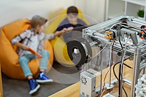 Little boys waiting for teacher in chair bags while sitting in laboratory