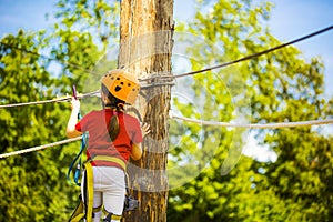 Little brave caucasian girl treerunner fasten the rollclip before climbing