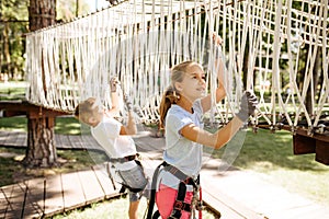 Little brave kids climbs on net in rope park