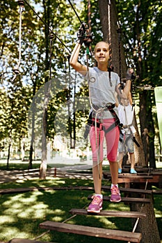 Little brother and sister climbs in rope park