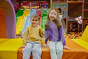 Little brother and sister cuddling together while rest at game center