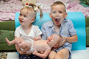 Little brother and sister rejoice at the newborn baby