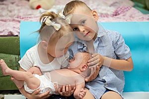 Little brother and sister rejoice at the newborn baby