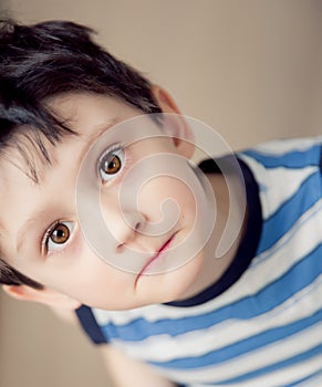 Little brunette boy wearing striped shirt indoor