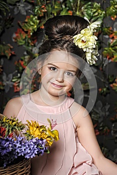 Little brunette girl with flowers in her hair and a basket of flowers portrait, retro style