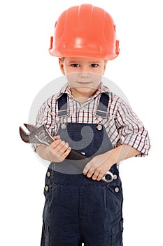 Little builder in coveralls and helmet with wrench