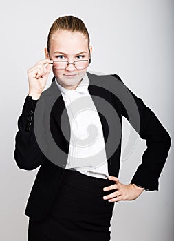 Little business woman in glasses thought of a new idea. Studio portrait of child girl in business style.