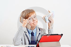 Little businessman talking by smartphone. Boy holding money. Future education, proffesion