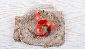 Little sack and red ripe tasty fresh cherry tomatos