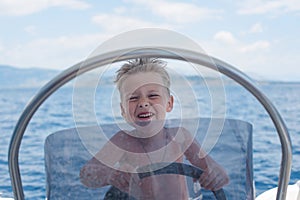 Little captain having fun on boat in the sea