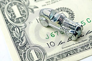 Little car made of chrome is laying on one dollar banknote