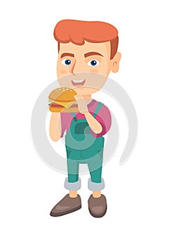 Little caucasian boy eating a hamburger.