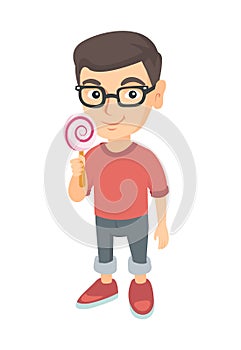 Little caucasian boy holding a lollipop candy.