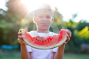 Little caucasian boy holding slice of watermelon