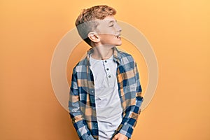 Little caucasian boy kid wearing casual clothes looking away to side with smile on face, natural expression