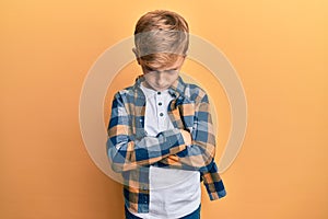 Little caucasian boy kid wearing casual clothes skeptic and nervous, disapproving expression on face with crossed arms