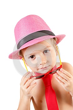 Little boy in tie, sunglasses, and hat is dancing, isolated on white. Little cute cheerful kid is dancing on white background.