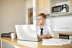 Little caucasian boy work on laptop at home