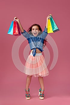 little caucasian child girl holds shopping bags