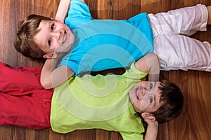 Little caucasian child playing with lots of colorful plastic blocks indoor. Kid boy wearing shirt and having fun building creating