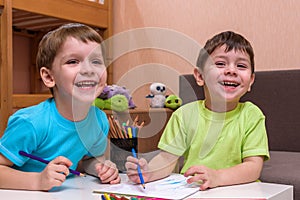 Little caucasian child playing with lots of colorful plastic blocks indoor. Kid boy wearing shirt and having fun building creating