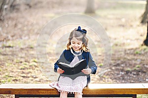 Little caucasian Christian girl reading the holy bible