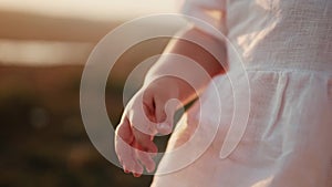 Little caucasian cute tender baby child girl holds pebbles in her hands