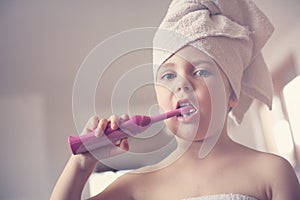 Little Caucasian girl brush her teeth in the bathroom.