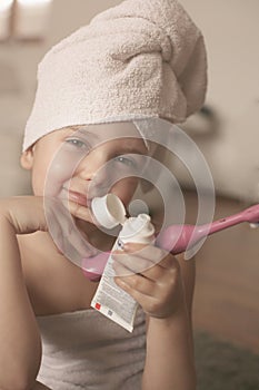 Little Caucasian girl brush her teeth in the bathroom.