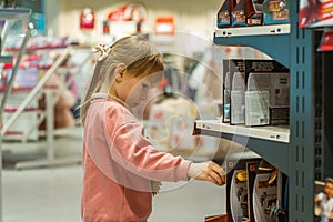 Little caucasian girl coosing a new toy in the big baby store