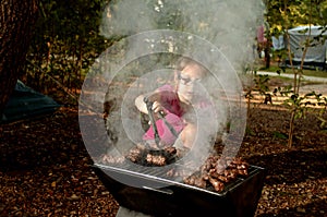 Little caucasian girl elementary age cooking the Ãâ¡evapi on ba photo