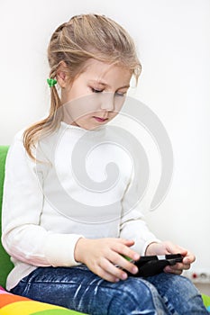 Little Caucasian girl has unlimited net access. Internet usage with smartphone