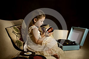 Little caucasian girl holding a single disc