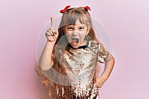 Little caucasian girl kid wearing festive sequins dress pointing finger up with successful idea