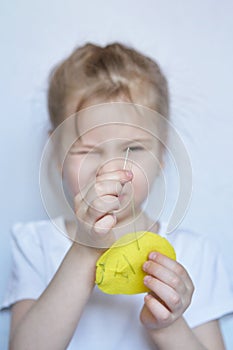 Little Caucasian girl learns to insert a thread into a needle.