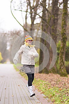 Little caucasian girl running in the park