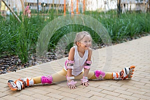 A little caucasian girl sits in a transverse twine shod in roller skates.