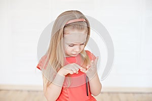 Little caucasian girl thoughtful counting her fingers indoors.