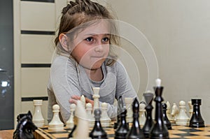 Little charming girl child playing chess