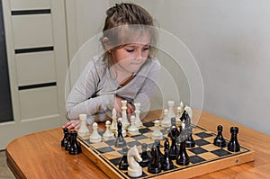 Little charming girl child playing chess