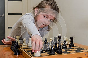 Little charming girl child playing chess