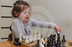 Little charming girl child playing chess