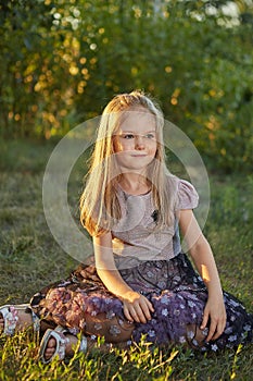 Little charming girl Sitting on the grass