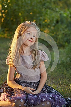 Little charming girl Sitting on the grass